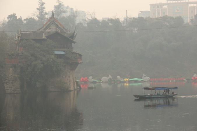 The Wangye Miao teahouse on the Fuxi river bend. The boat pictured ferries locals back and forth across the river underneath the teahouse windows.