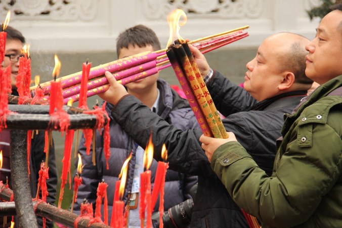 Buddhist worshipers light incense 