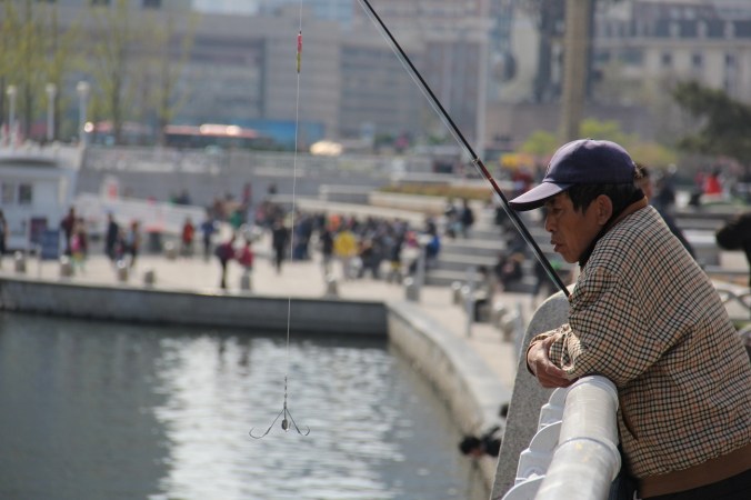 A man takes a break from fishing near the train station.