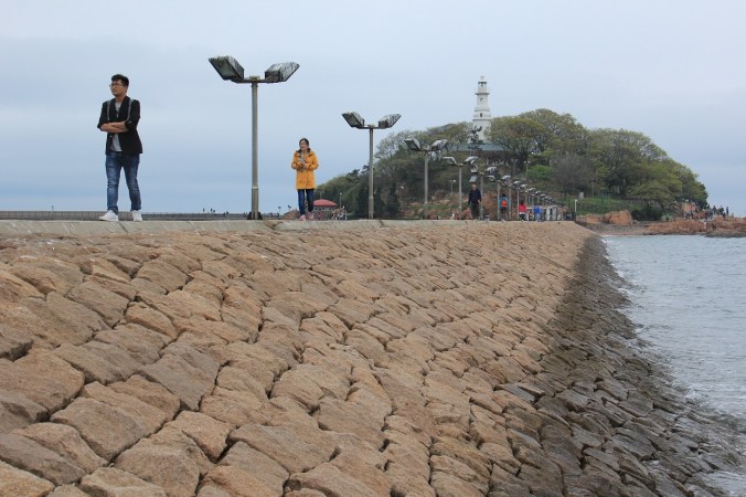The Little Qingdao lighthouse watches over the harbor and the seawall protects it.