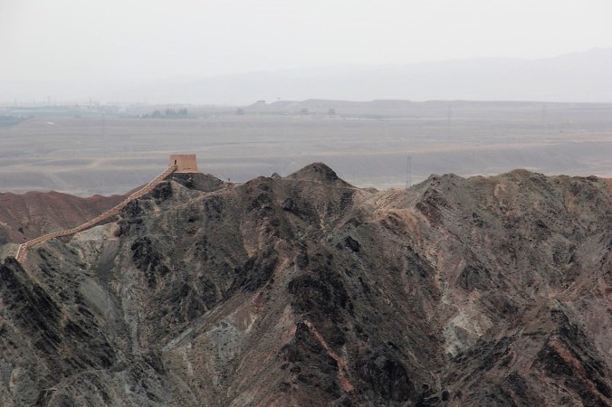 The Great Wall snakes along the hills, then connects with Jiayuguan in the distance.